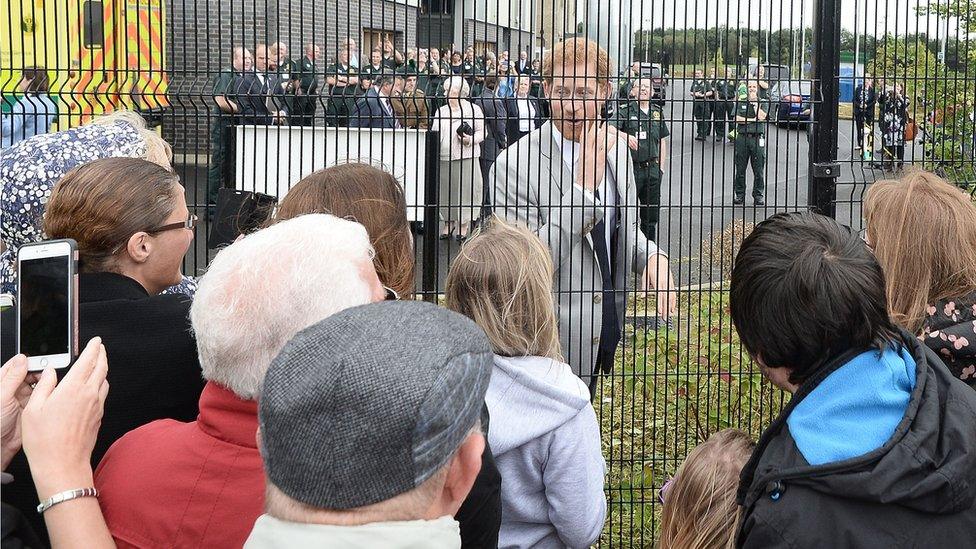 Members of the public took photos of the prince outside the ambulance station