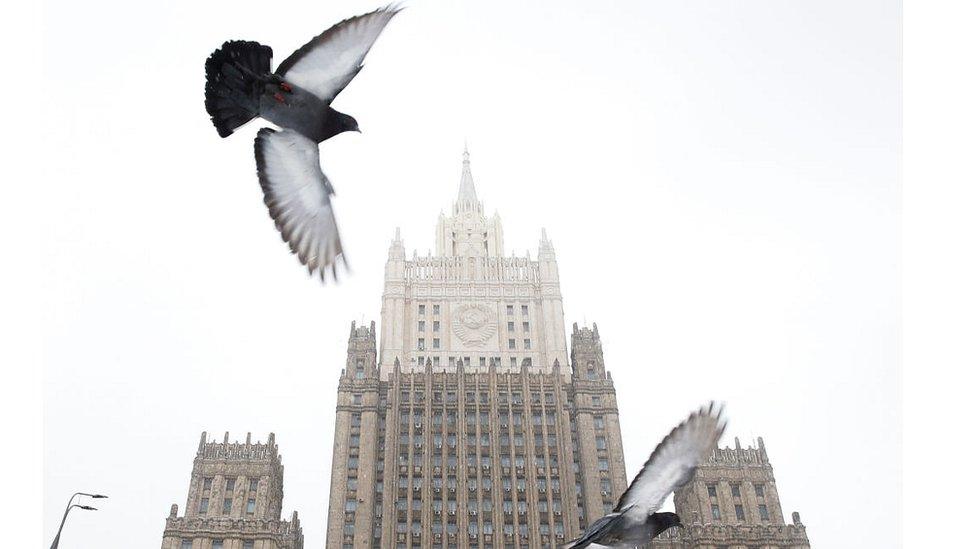 Pigeons fly in front of the Russian Foreign Ministry headquarters in Moscow on March 27, 2018.