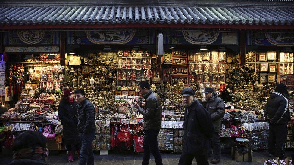 Chinese shoppers walk through a market