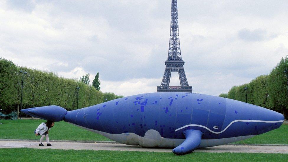 An inflatable whale sits near the Eiffel Tower in Paris as part of Earth Day celebrations