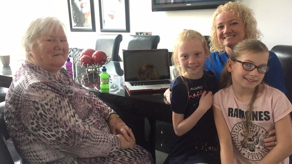 Agnes Lattimer, Kim Fenton and Kim's two grand-daughters sitting around the kitchen table at their home in east Belfast