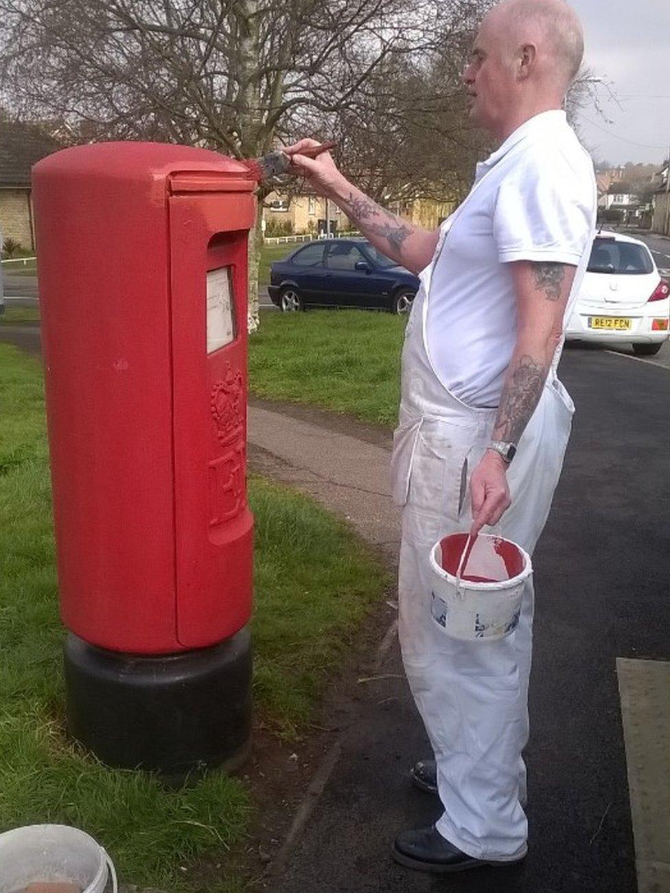 Ray Powell painting a post box