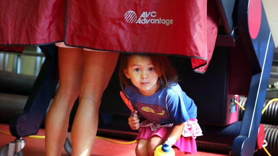 Child peers out as her mother votes in Mendham Township, New Jersey, on 7 June 2016