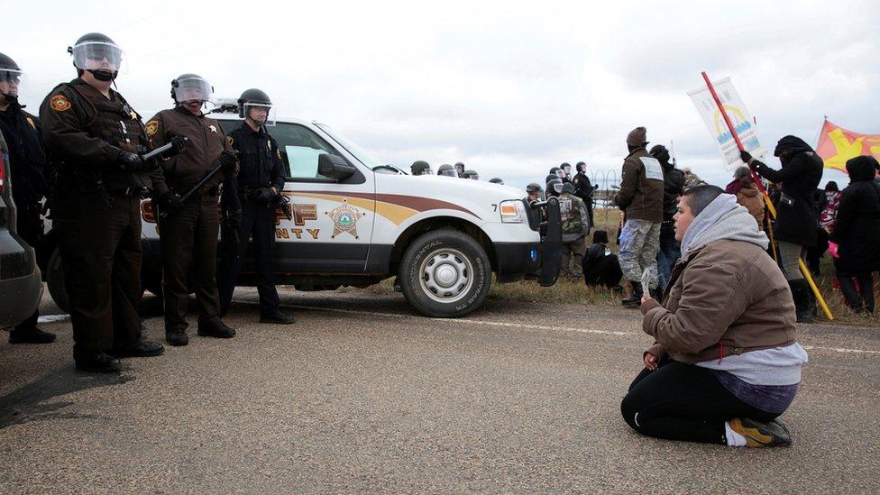 Caro Gonzales of Olympia, Washington, prays in front of police during a protest against the Dakota Access Pipeline between the Standing Rock Reservation and the pipeline route outside the little town of Saint Anthony, North Dakota, U.S., October 5, 2016.