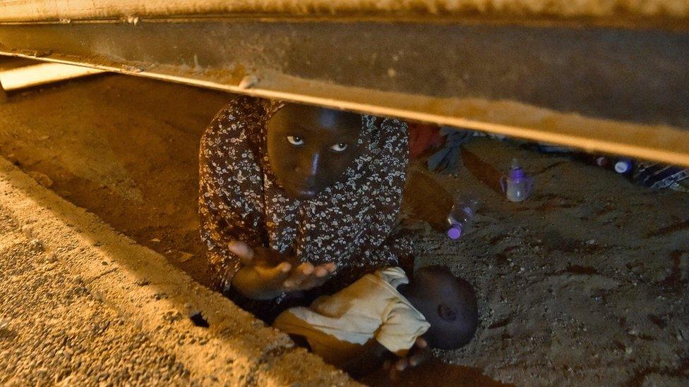 A migrant from Niger hides with her newborn child to avoid deportation at a transit centre in Tamanrasset in southern Algeria, 2 July 2018