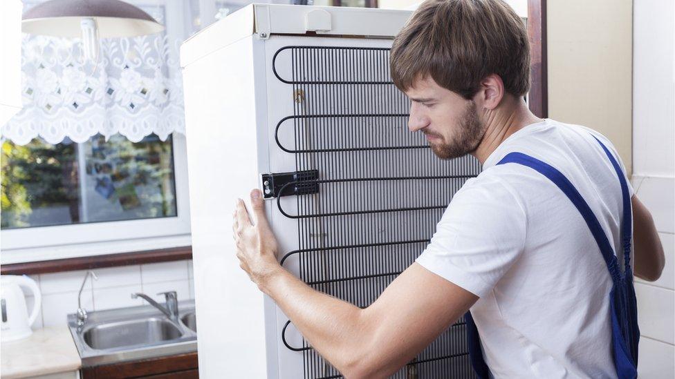 workman removes fridge