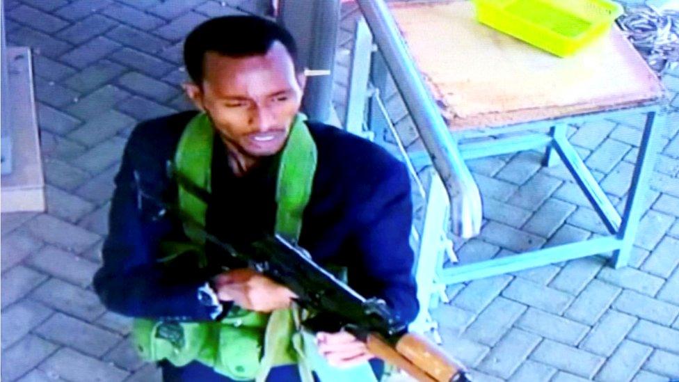 A gunman is pictured as he and others make their way into a hotel and office complex in Nairobi, Kenya, 15 January 2019