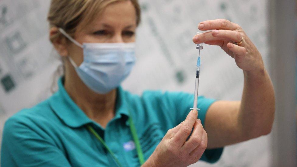 A vaccinator prepares vaccines at a COVID-19 booster vaccination centre