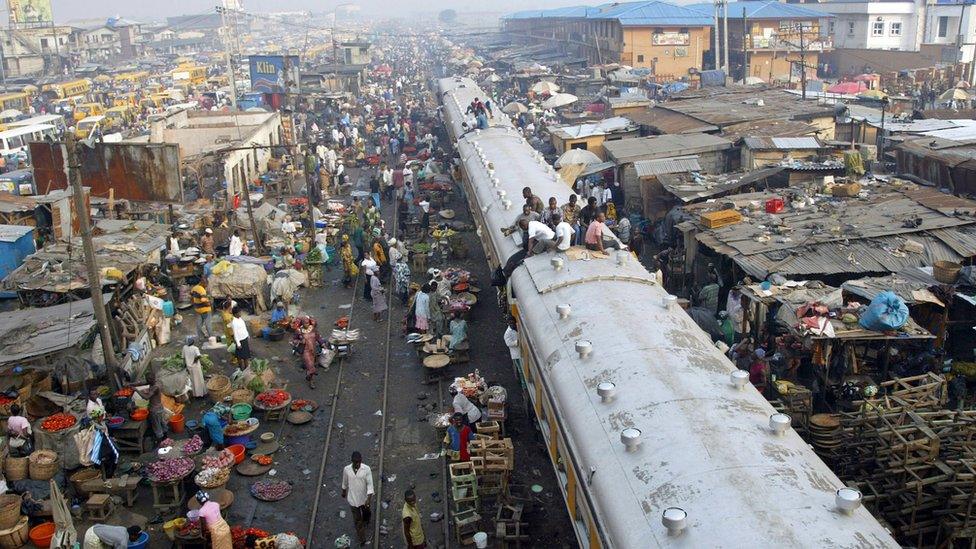 Commuters sitting on top of a train in Lagos, Nigeria.