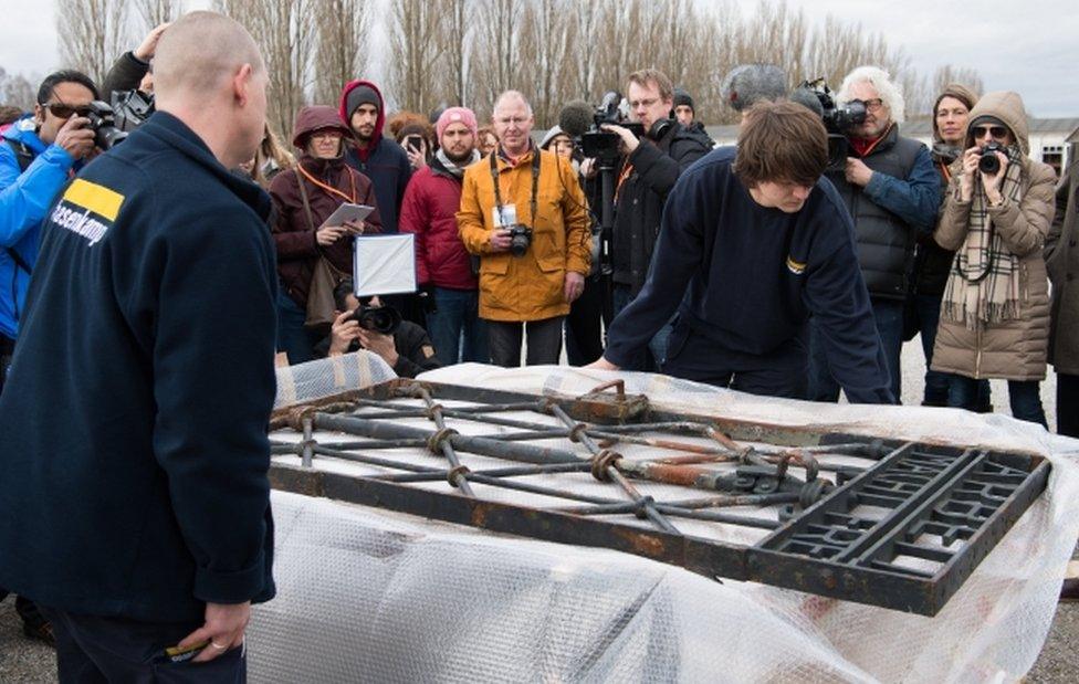 Workers unpack the iron gate after its return to Dachau on 22 February, 2017