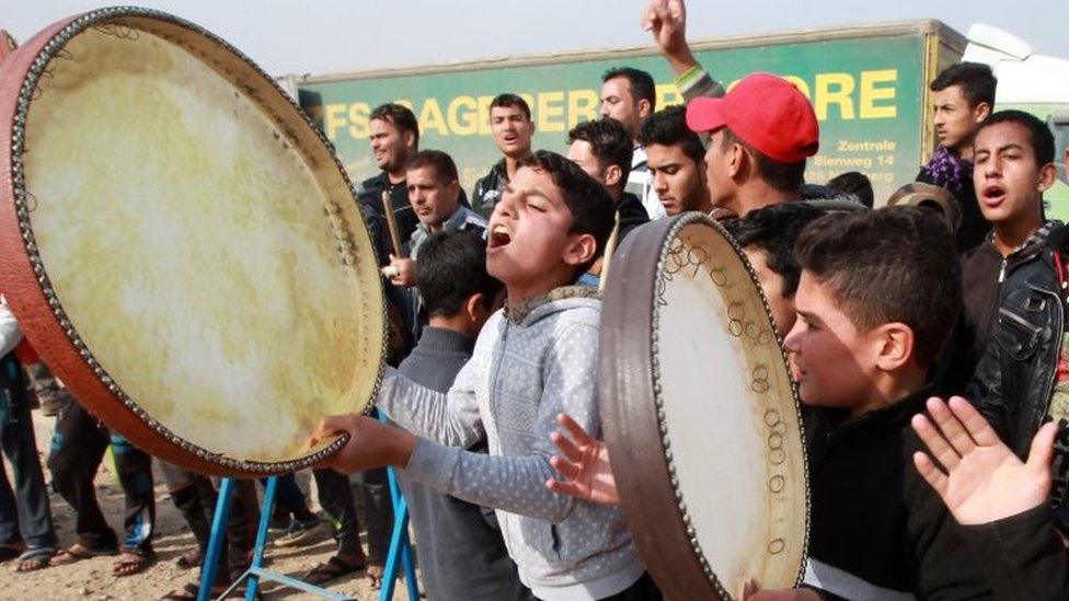 Displaced Iraqi people, who fled the violence in the Iraqi city of Ramadi, celebrate after their city was recaptured