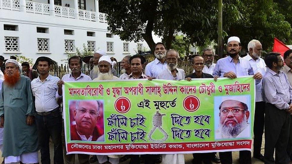 Bangladeshis who fought in the 1971 war of independence against Pakistan hold a banner calling for the execution of Salahuddin Quader Chowdhury (left) and Ali Ahsan Mohammad Mujahid (right) in November 2015