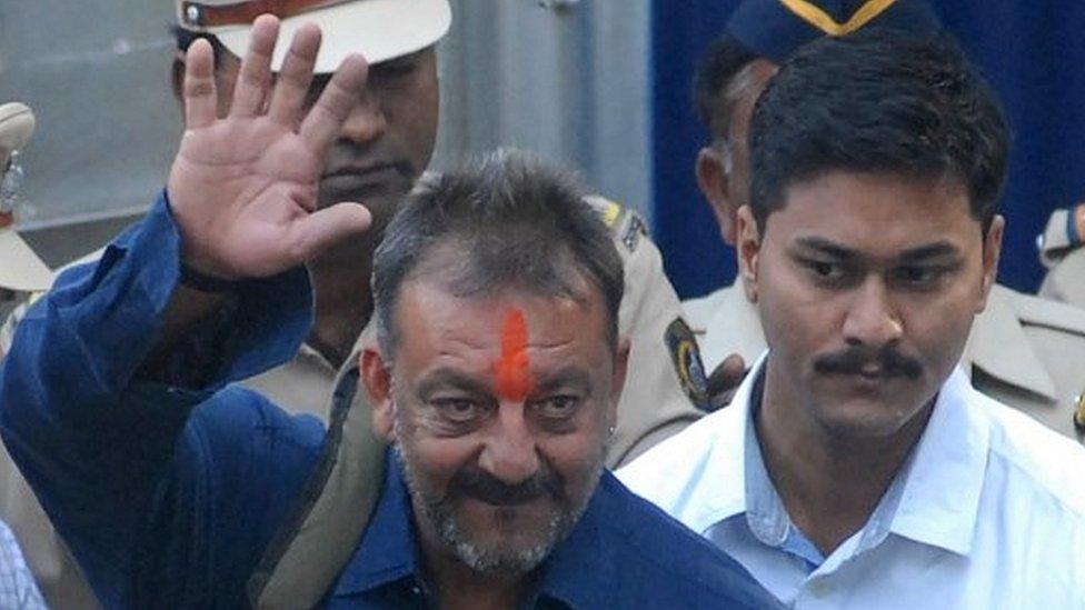 Bollywood actor Sanjay Dutt (C) waves as he is escorted by officials from Yerwada Jail in Pune on February 25, 2016