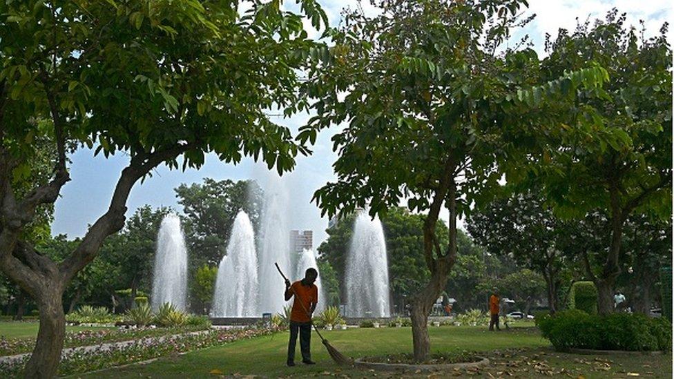 A worker cleans a park ahead of the two-day G20 summit in New Delhi on September 7, 2023.