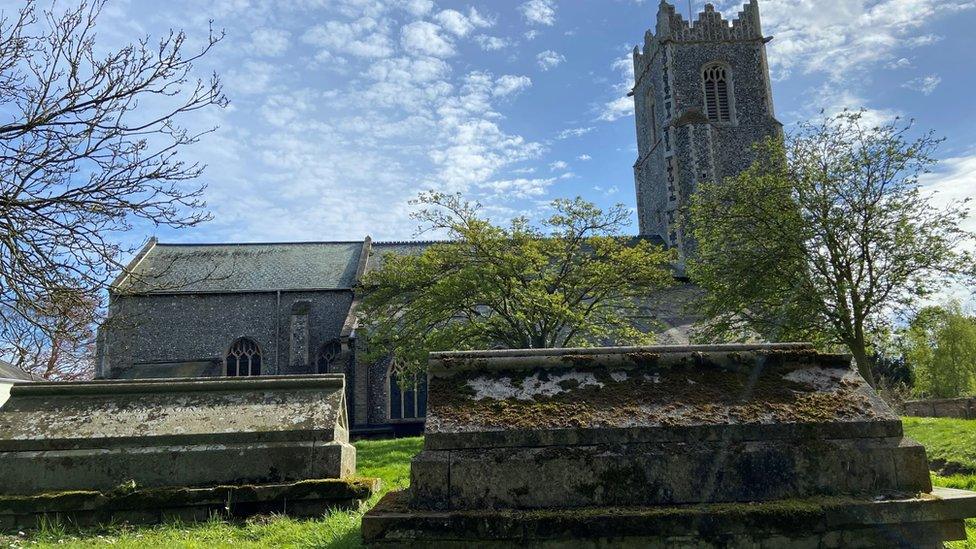 St Margaret's church, Ormesby, Norfolk, with trees in the foreground and blue skies