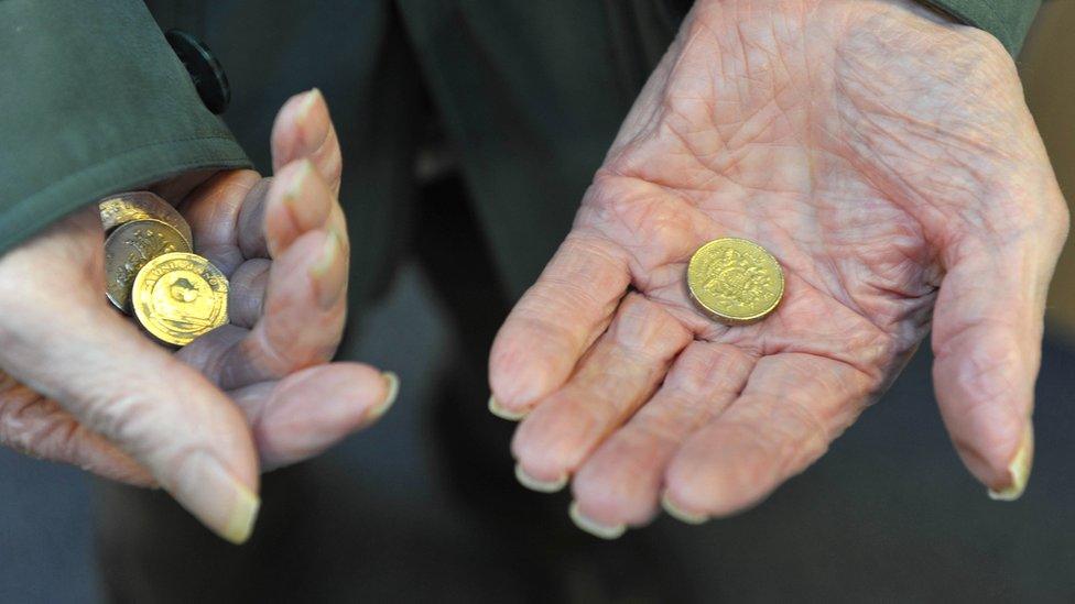 Elderly person's hands holding coins