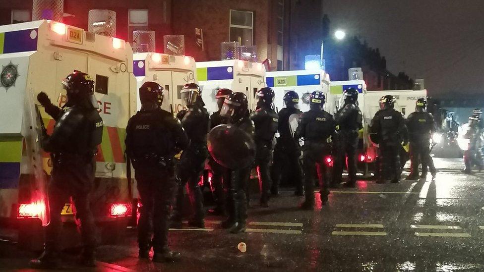 A line of police officers standing next to police jeeps on Wednesday night