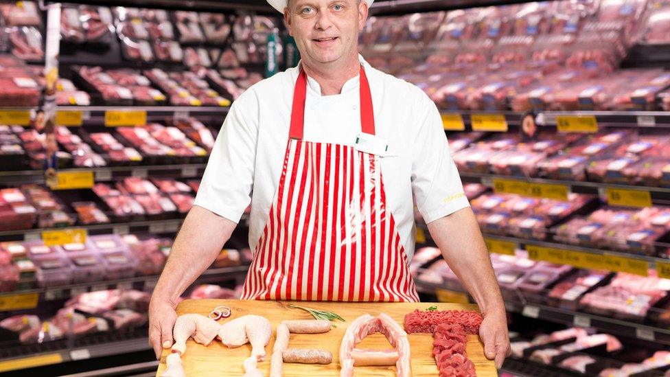 A Morrisons butcher displays some of the supermarket's meat offers