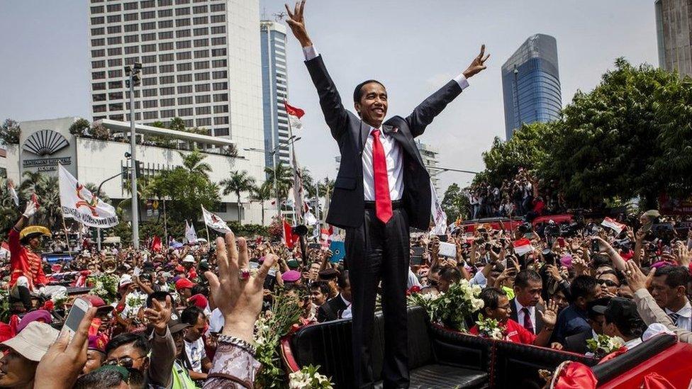 Indonesian President Joko Widodo waves to the crowd while on his journey to Presidential Palace by carriage during the ceremonial parade on 20 October 2014 in Jakarta, Indonesia.