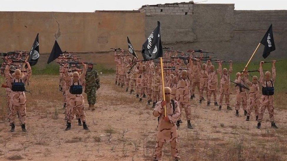 Young boys known as the "lion cubs" hold rifles and Islamic State group flags at a training camp near Tal Afar, Iraq