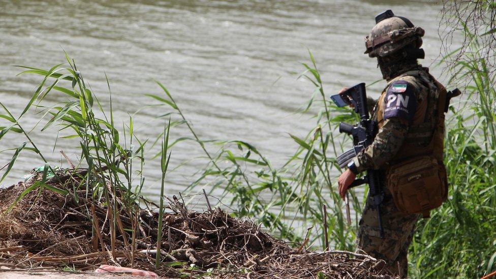 A member of the Mexican Police patrol the area where the dead bodies of a presumed migrant and his baby were found