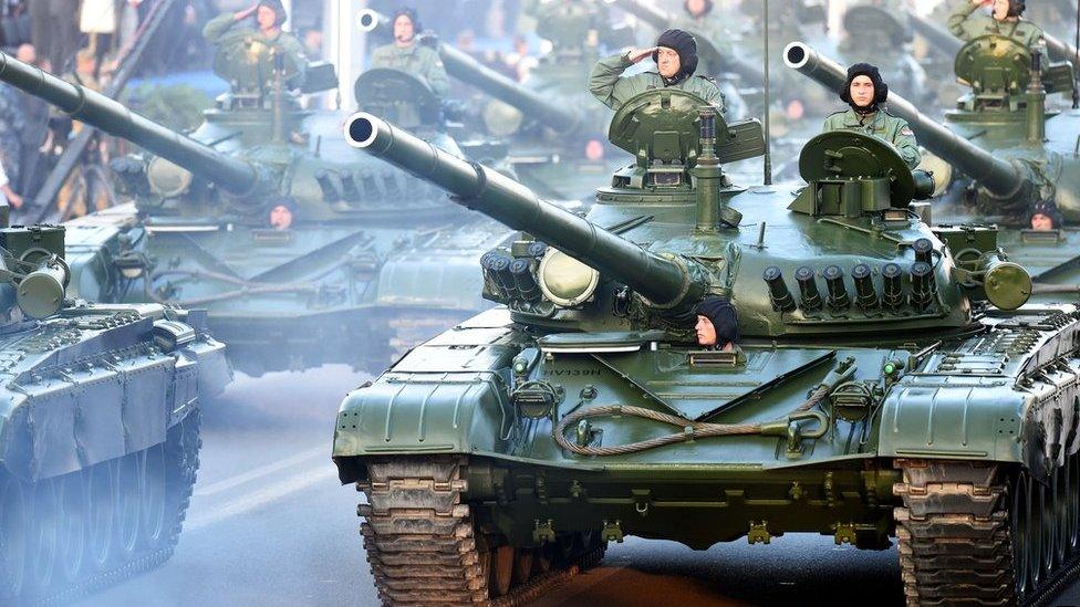 Croatian soldiers salute on top of armored vehicles on August 4, 2015 in Zagreb, during a military parade to mark the 20th anniversary of Operation Storm