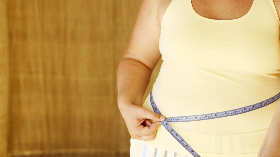 A woman measuring her waist