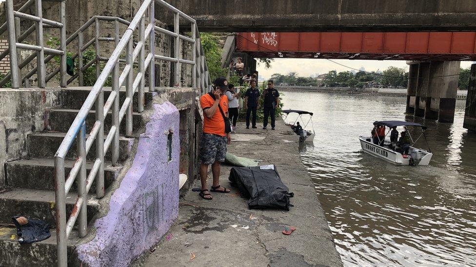 Coastguard officials with the retrieved body in Manila