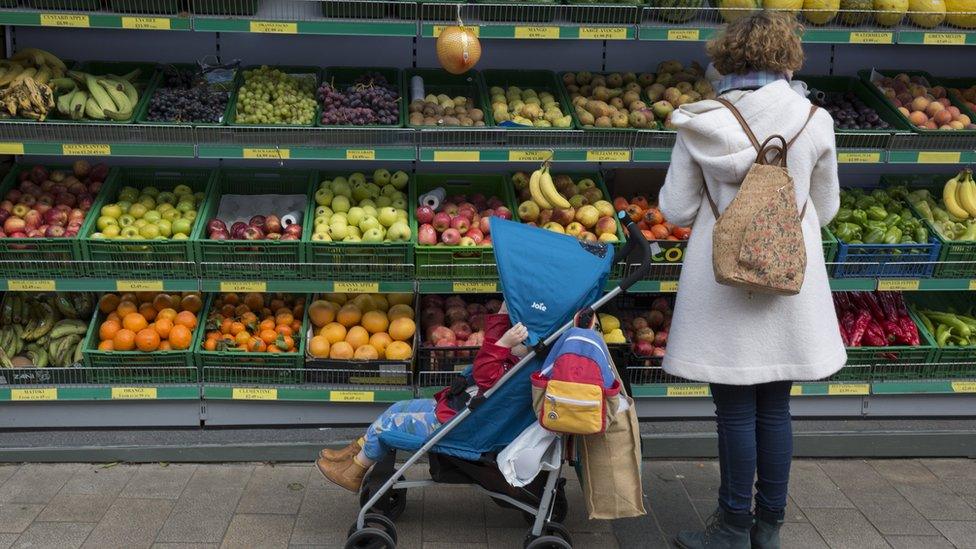 Mother and child buy fruit at the supermarket