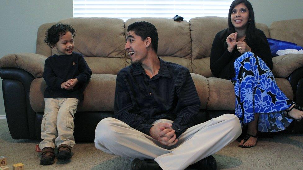 Jose Escobar, from El Salvador, shares a laugh with his son, Walter, next to his wife, Rose Marie Ascencio-Escobar, at their south Houston home on 27 January