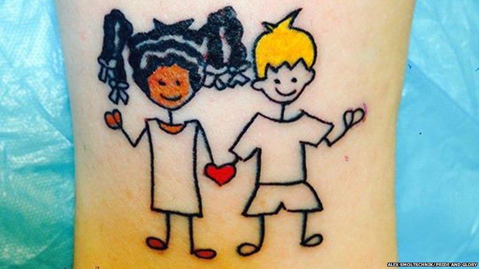 A tattoo showing a girl and boy with different skin colours holding hands