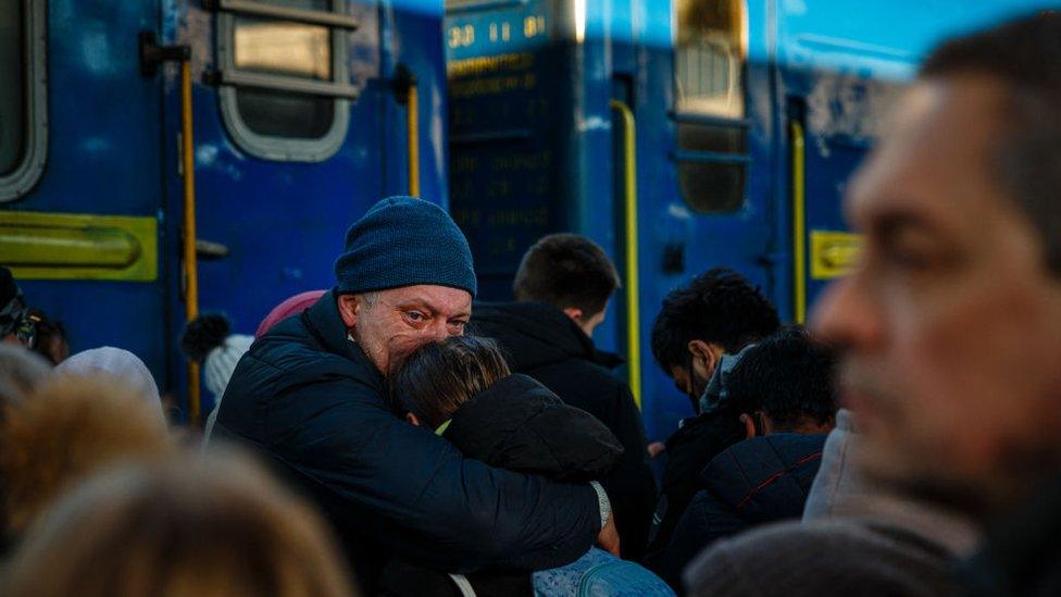 A man says goodbye to his daughter before she boards an evacuation train at Kyiv's central railway station on 28 February 2022