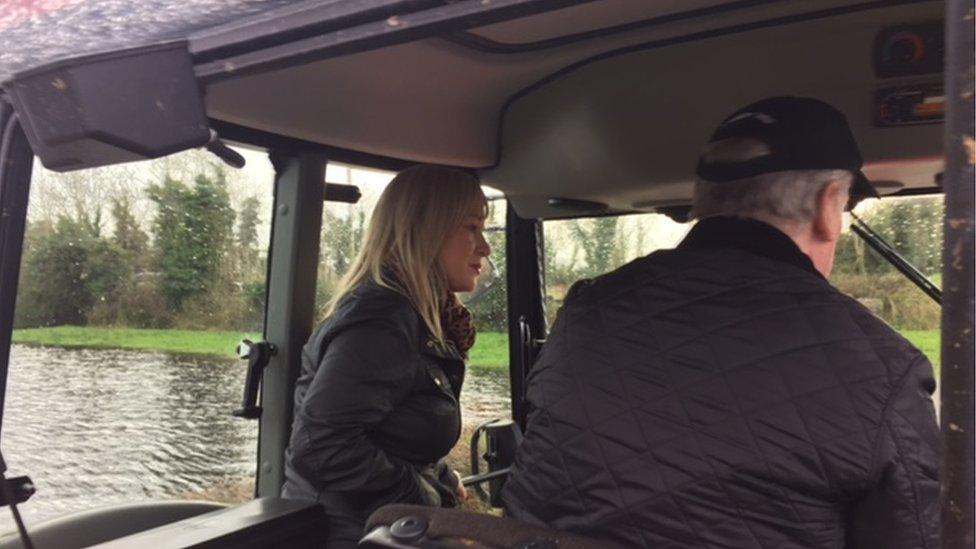 Michelle O'Neill on a tractor in flood water