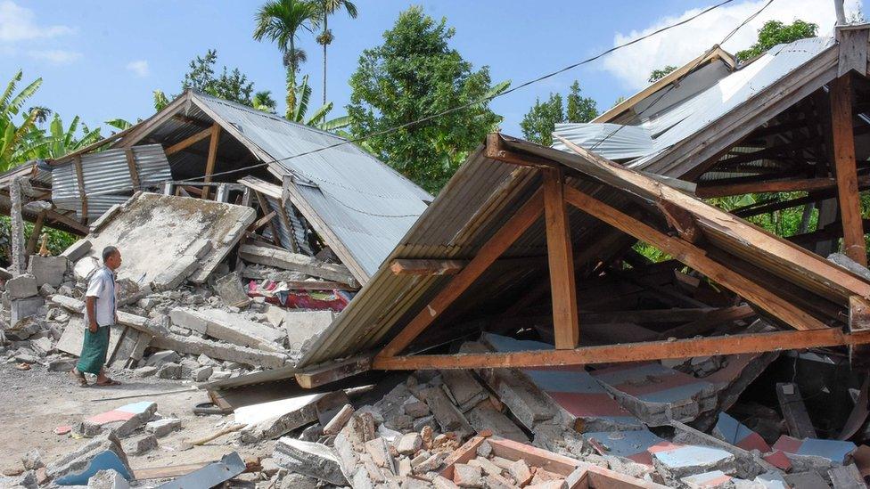 An Indonesian man examines the remains of houses, after a 6.4 magnitude earthquake struck, in Lombok on July 29, 2018