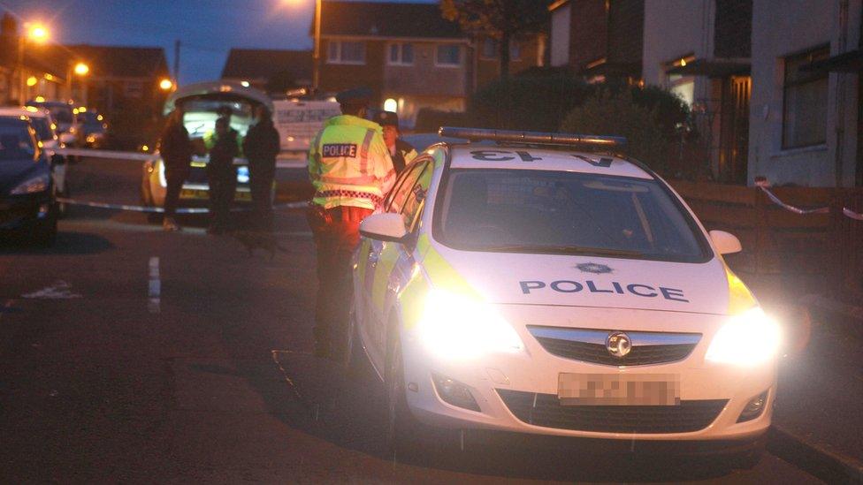 Police officers and vehicles at the scene of the incident in Newtownabbey