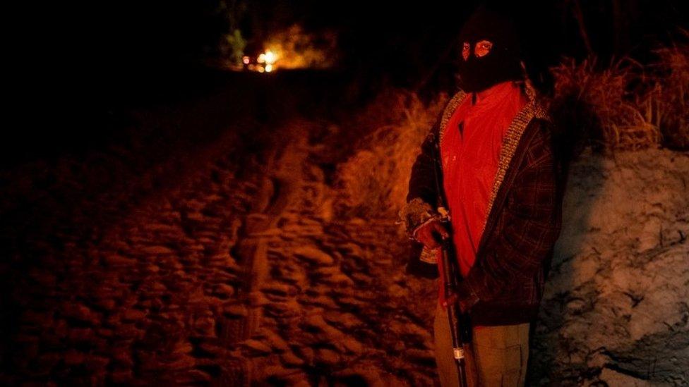 Paulo Paulino Guajajara holds a gun during the search for illegal loggers in September