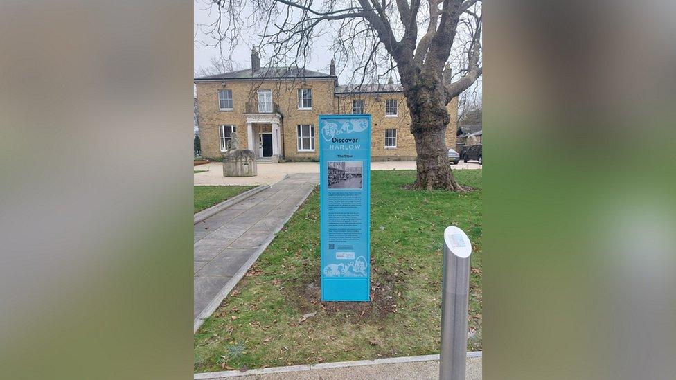 Blue heritage signpost in the grass