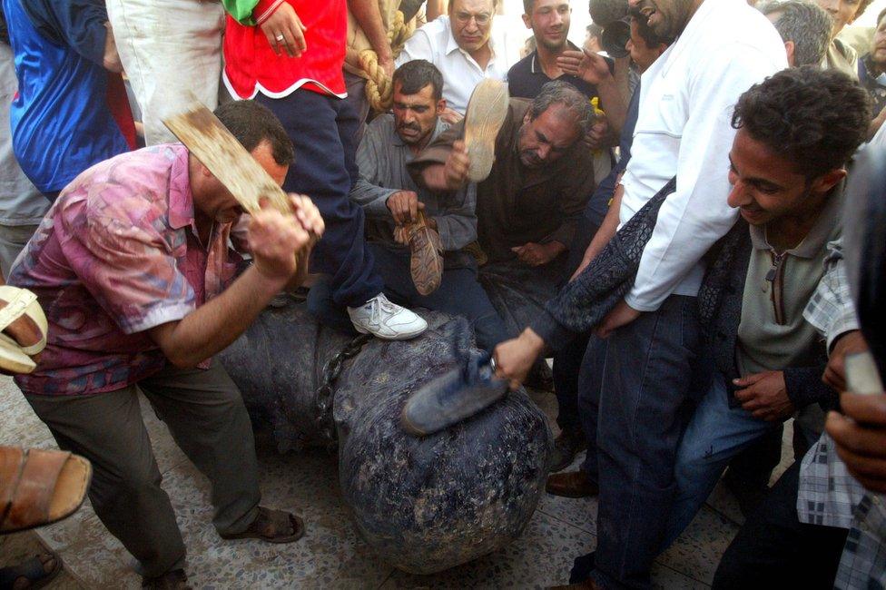 Beating a statue of Saddam Hussein in Baghdad