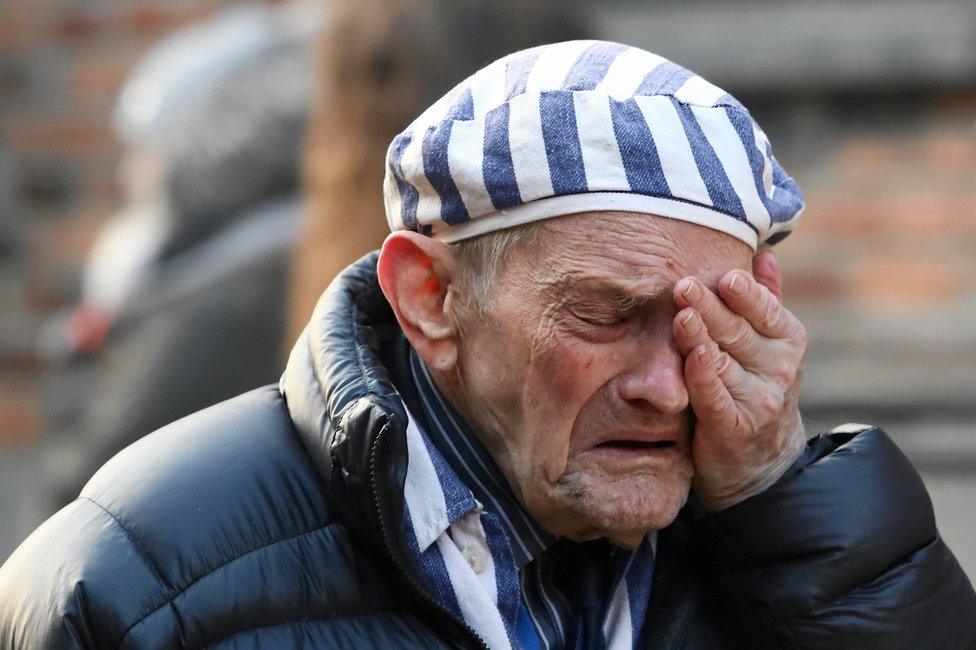 A survivor reacts at a Holocaust wreath-laying ceremony