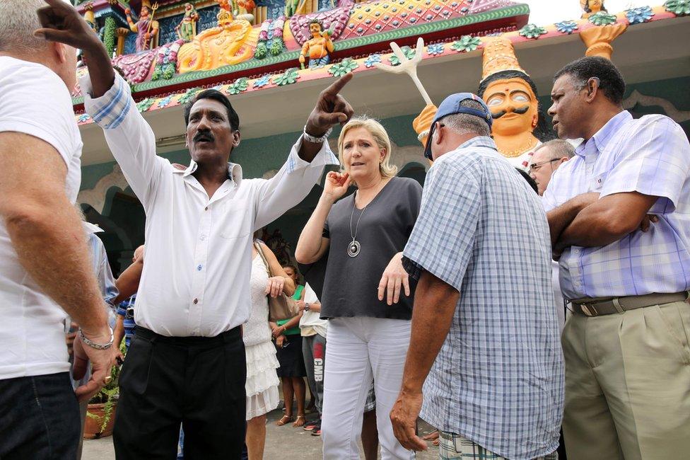 Marine Le Pen (C) visits a Hindu temple in Saint-Louis, on the Indian Ocean island of La Reunion, 27 November