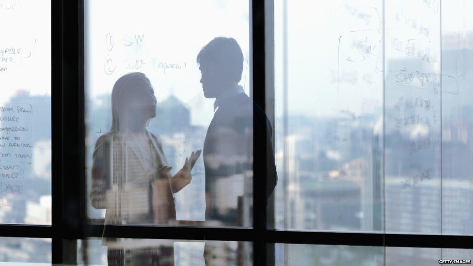 A woman and man talk at work