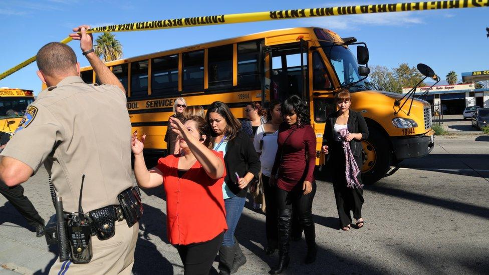 Staff and residents are led away from the site of the shooting.