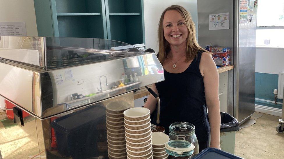 A woman standing by a coffee machine