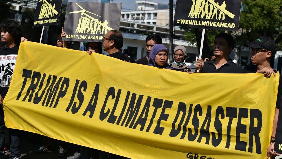 Greenpeace activists display a banner during a rally in front of the US embassy in Jakarta on June 7, 2017