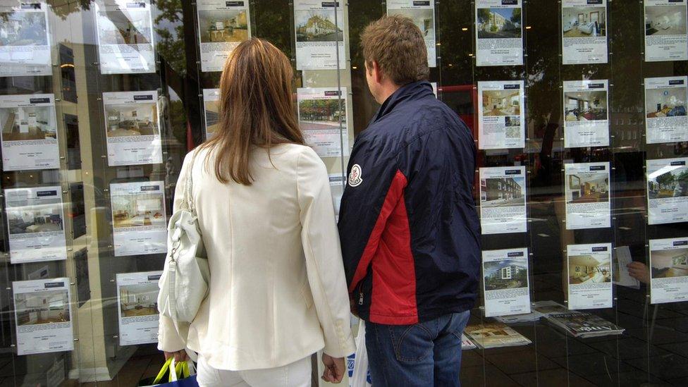 Couple look in estate agent's window