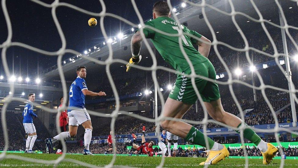 The Everton defence watch as Garnacho's kick fires the ball towards goal.