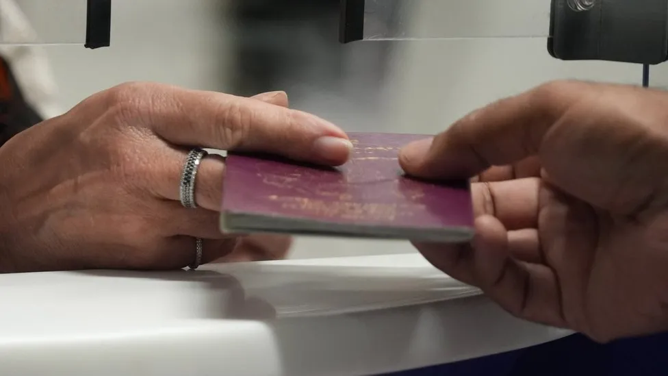 A passport being passed across adesk