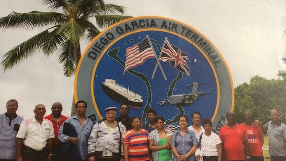 First generation Chagossian exiles standing in front of the military airbase on Diego Garcia