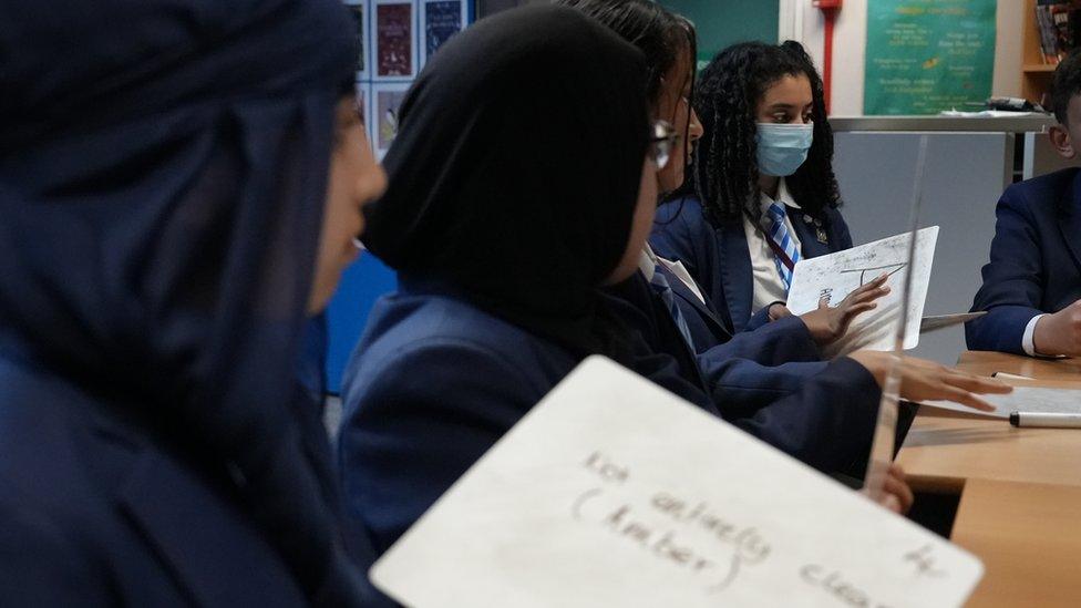 Girls holding whiteboards in class