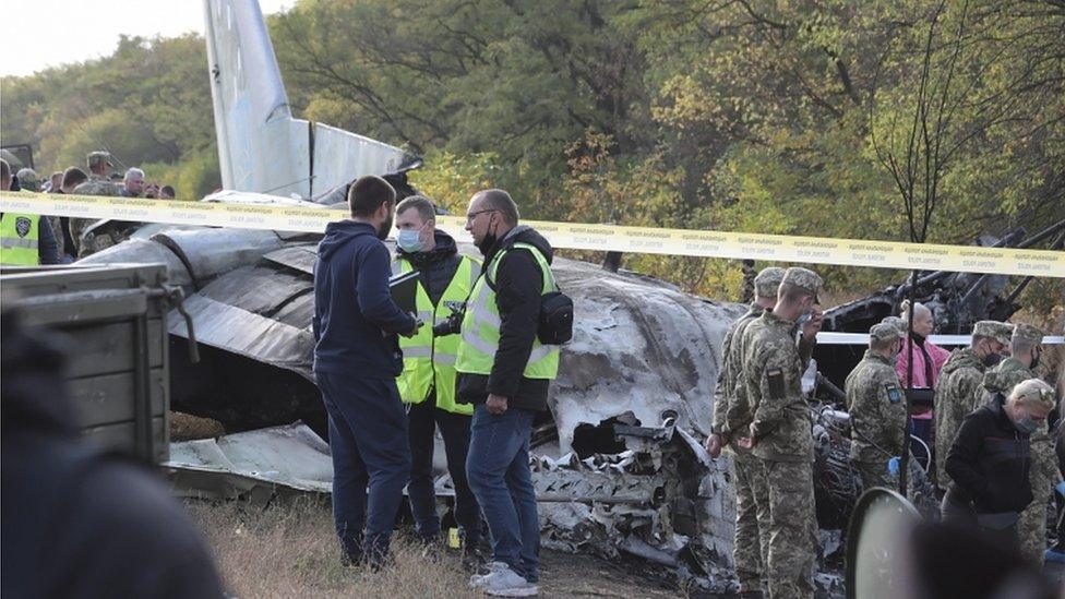 Rescuers inspect the crash site of the An-26 plane near Kharkiv, Ukraine, on 26 September 2020